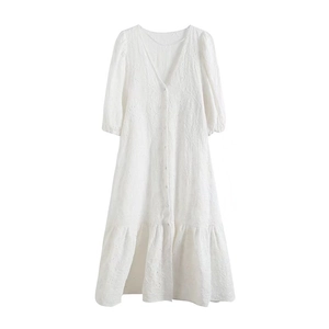 Détail d'une robe blanche en dentelle avec décolleté en V et boutons sur le devant