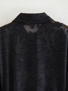 Nahaufnahme von schwarzem, transparentem Stoff mit aufwendiger Jacquard-Blumentextur