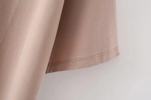 Close-up of the double-needle hem stitching and dusty pink knit fabric texture