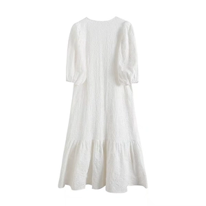Détail de la broderie évidée et de l'ourlet à volants sur la robe midi blanche