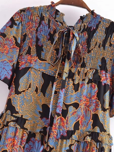 Close-up of bohemian floral dress with smocked bodice and tie-knot neckline detail