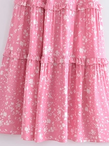 Détail de la robe rose à fleurs avec couches à volants et motifs floraux délicats