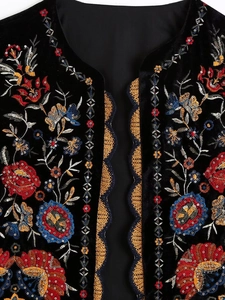 Détail de broderie florale et de paillettes sur un gilet en velours noir