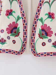 Detailed view of intricate floral embroidery and geometric trim on an ethnic style vest