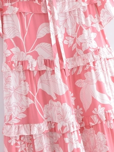 Close-up of pink floral dress featuring tiered ruffle hem and delicate tie neckline