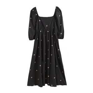Detail of floral embroidery on black square neck midi dress with puff sleeves