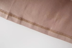Detailed close-up of overlock stitching on mauve Y2K skinny high-stretch knit fabric