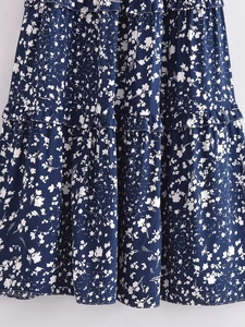 Détail du tissu en rayonne fleurie bleu marine montrant les volants et les coutures fines