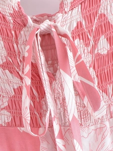 Detail of pink floral smocking fabric on a summer dress with delicate tie-up straps