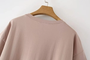 Detail showing reinforced double-needle stitching on back neckline of dusty pink T-shirt