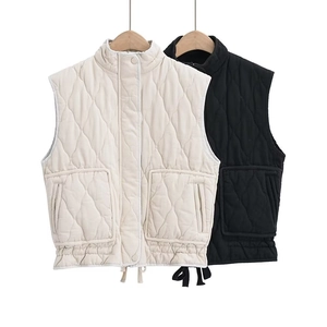 Close-up of quilted vest detail with standing collar and large utility pockets