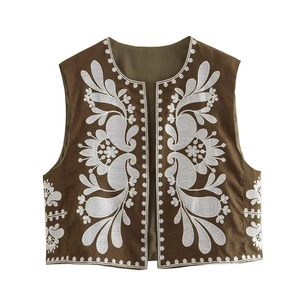 Detailed close-up of white floral embroidery on a brown bohemian sleeveless vest jacket