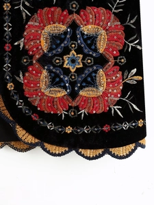 Détail de la broderie ethnique et des paillettes sur velours noir avec bordure crochetée