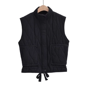 Detail of diamond quilted black vest featuring a stand collar and adjustable hem drawstrings