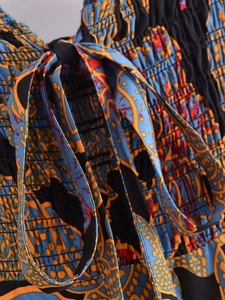 Detail of smocking texture and paisley floral print on bohemia summer dress with drawstring