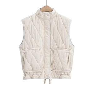 Detail of light beige quilted vest featuring standing collar and drawstring hem