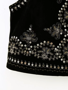 Close-up of silver sequin embroidery and floral patterns on black velvet vest fabric