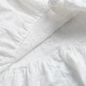 Gros plan détaillé du tissu en coton blanc avec broderie anglaise et volants élégants