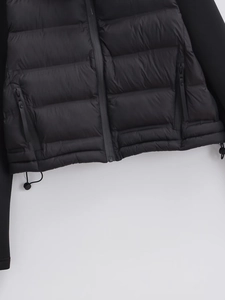 Detail of quilted jacket showing a zip pocket and adjustable drawstring at the hem