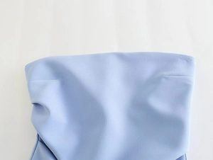 Detail of light blue bandeau top featuring pleated design and high-quality woven fabric