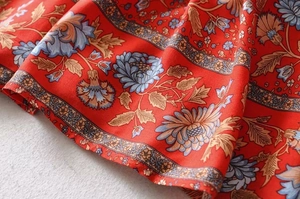 Close-up of red Y2K floral print fabric with vintage ruffles and bohemian summer textures