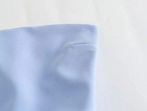 Macro detail of light blue Y2K tube top showing seamless hem and refined fabric texture