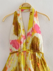 Dettaglio vestito allacciato al collo con stampa tie-dye e vita alta elastica a pieghe