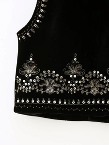 Detail of velvet vest showing silver sequins and gold floral embroidery on the hemline