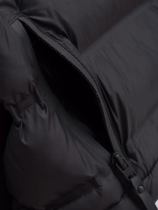 Macro detail of waterproof zipper pocket and matte texture on black cotton jacket
