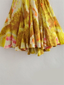 Vista dettagliata del motivo tie-dye sull'orlo fluido di un mini abito stile Y2K
