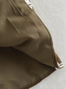 Detailed close-up of brown floral vest showing fine stitching and white striped lining