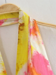 Dettaglio dello scollo a V e della vivace stampa tie-dye su un abito estivo Y2K halter