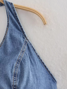 Close-up of vintage Y2K denim halter top with orange contrast stitching and fabric texture