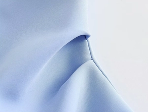 Close-up of light blue Y2K tube top showing pleated design and fine stitching details