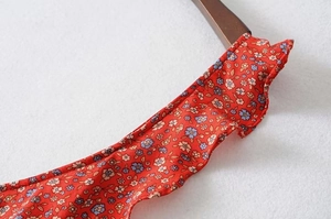 Detail shot of the ruffled neckline and strap on the red floral Y2K summer dress