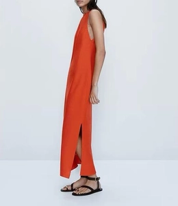Détail de la robe longue orange sans manches avec fente latérale haute et tissu léger
