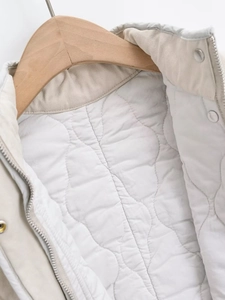 Detailed macro view of quilted lining, metal zipper and stand collar of the vest