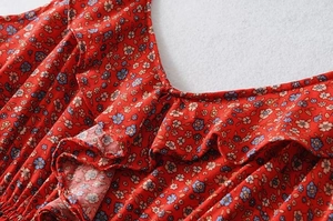 Detail view of red floral summer dress featuring ruffle edges and vibrant tiny flower print
