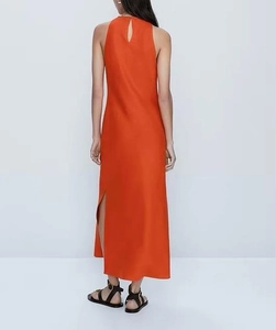 Détail de la robe longue orange sans manches en satin avec fente au dos et goutte d'eau