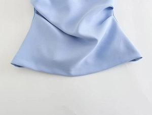 Close-up of the ruffled hem design and draped texture on a light blue summer tube top