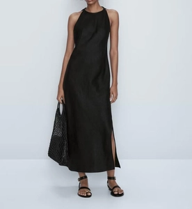 Détail de la texture en satin de soie et fente latérale haute sur une robe longue noire
