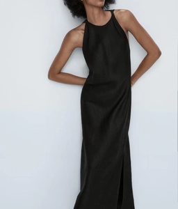 Détail de la robe longue sans manches noire Y2K avec décolleté licou et fente latérale