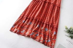 Detail of red floral tiered dress featuring layered ruffle hem and Y2K vintage patterns