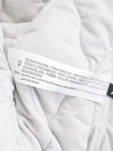 Close-up of the internal fabric care label showing 100% cotton material on Y2K vest