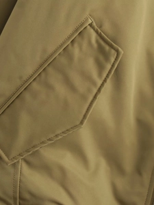 Detailed close-up of olive green Y2K bomber jacket featuring a pocket with double stitching