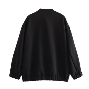 Back view of a loose-fit black bomber jacket with drop shoulders and ribbed cuffs