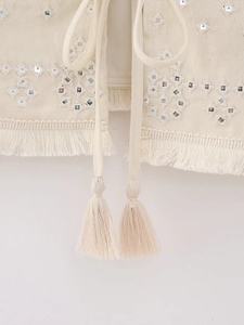 Detailed embroidery with mirror inserts and fringe on a bohemian linen vest top