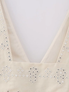 Detailed close-up of V-neck top featuring ethnic embroidery and shimmering sequins