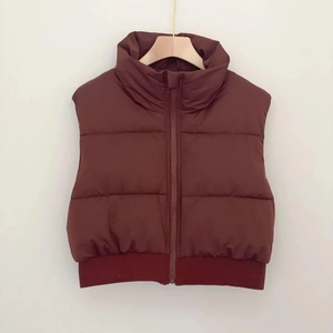 Detail of caramel puffer vest with high collar and ribbed hem for street fashion style