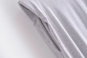 Macro detail of side pocket stitching on grey heather cotton t-shirt fabric texture